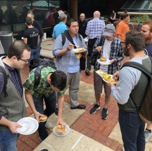 a photo of students eating burgers at a cookout