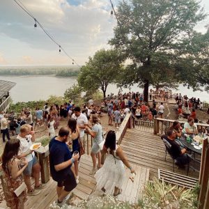 a photo of students at a party by the river