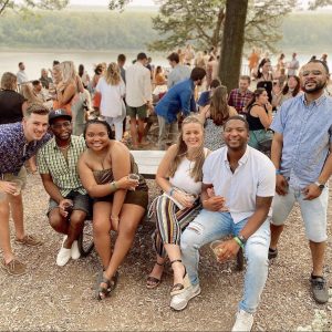 a photo of students at a party by the river