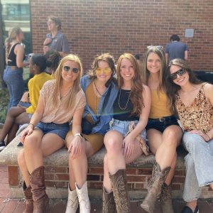 a photo of students in black and gold at a tailgate